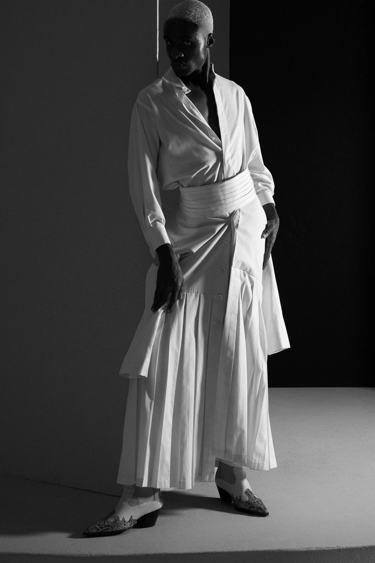 Rohan in a sculptural white ensemble, black-and-white editorial photograph