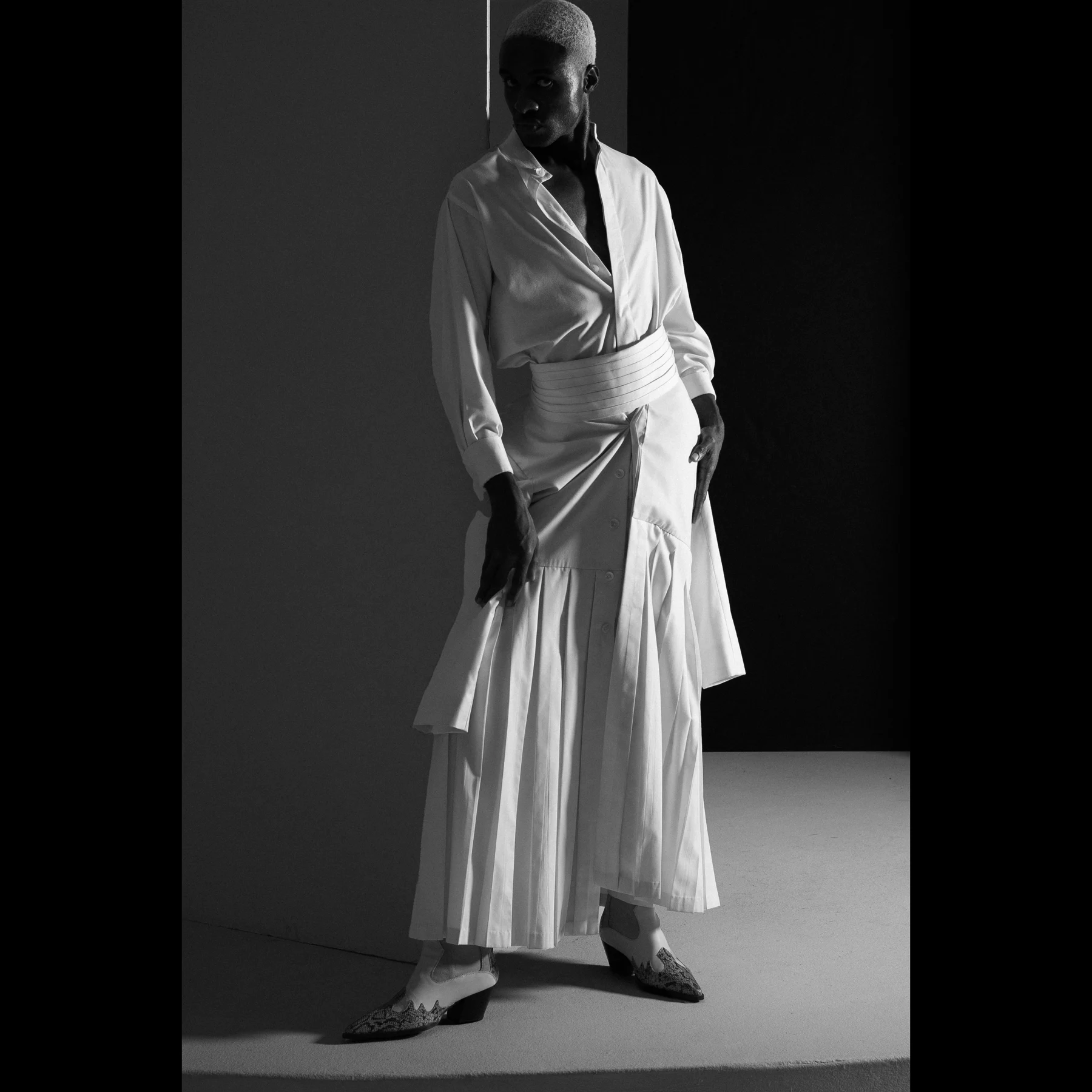 Rohan Williamson in a sculptural white fashion look, black-and-white editorial portrait
